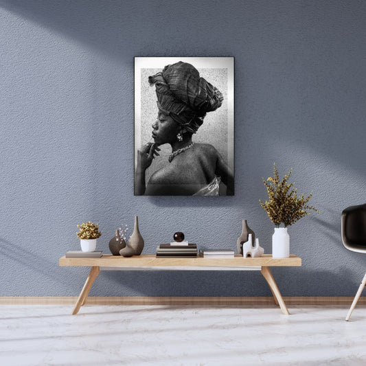 Framed artwork of a woman with a headscarf on a wall above a wooden console table with decorative items.